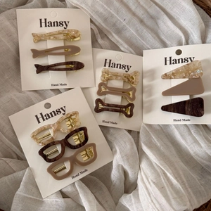 Star and geometric acetate hair clips set in marble beige and brown on linen fabric