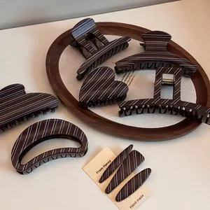 Elegant deep brown hair claws with white stripe pattern in various geometric shapes