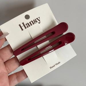 Détail de barrettes bordeaux montrant les finitions mates et brillantes sur carte