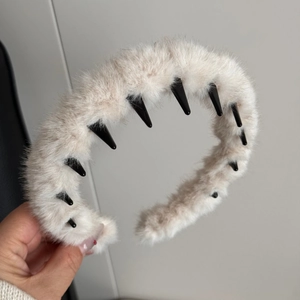 Détail d'un serre-tête en peluche beige avec des dents antidérapantes pour une tenue parfaite