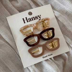 Detailed set of three eyewear-shaped acetate hair clips in varied colors on display card