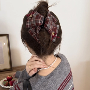 Close-up of vintage plaid bow hair claw clip with wooden buttons for elegant updo hairstyles