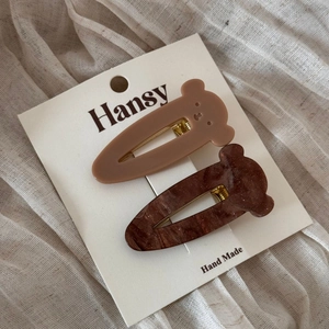 Detail of bear-shaped acetate hair clips in brown and glitter coffee on a display card