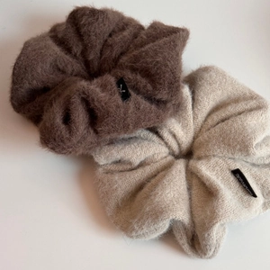 Gros plan de chouchous en peluche café et tricot beige avec étiquettes faites main