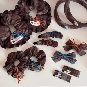 Detailed flat lay of handmade plaid fabric hair accessories with cute teddy bear charms