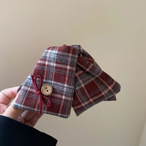 Macro detail of red and gray plaid bow hair claw clip with wooden button and suede bow decor