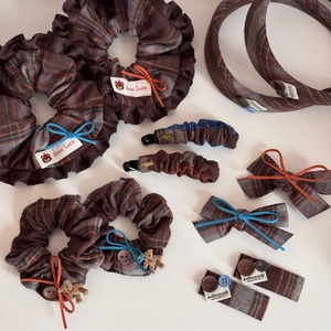 Detail view of winter plaid hair accessories with wooden buttons and warm fabric texture