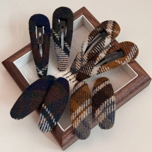 Détail de pinces à cheveux vintage en tissu écossais aux textures de tweed automne hiver
