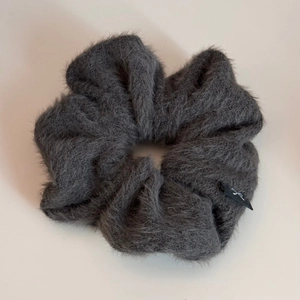 Gros plan sur le chouchou en peluche gris foncé avec texture douce en fausse fourrure