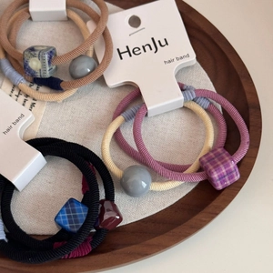 Elastici per capelli colorati con cubi a scacchi e perline opache sul vassoio