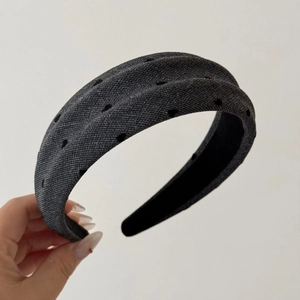 Detailed texture of thick grey headband with black flocked polka dots and non-slip lining