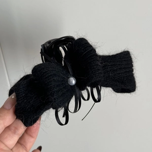 Detailaufnahme der schwarzen Strick-Schleife Haarklammer mit Perle und Bändern