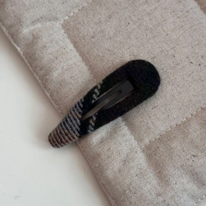 Gros plan détaillé d'une barrette BB en tissu écossais rétro avec texture en laine