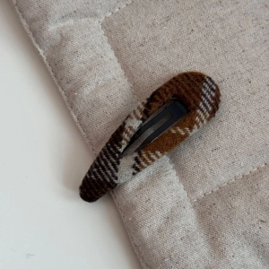 Gros plan sur la pince à cheveux BB en tissu écossais marron au style vintage