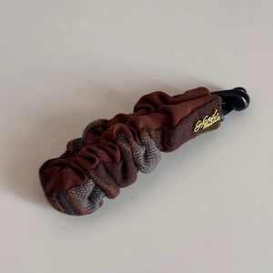 Close-up of brown checkered banana hair clip with gold Handmade metal hardware