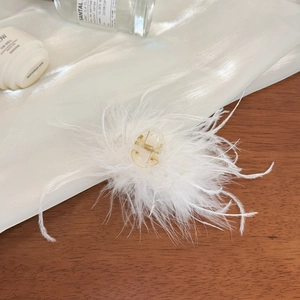 Elegante pinza para el cabello con plumas blancas y núcleo dorado transparente
