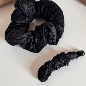 Détail d'une pince banane et chouchou en velours noir vintage avec texture gaufrée