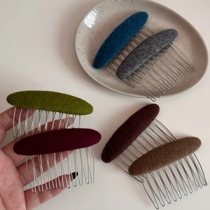 Detailed close-up of colorful oval fabric hair combs with silver metal teeth set