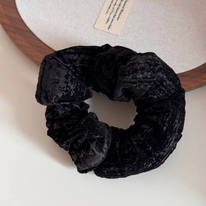 Vue détaillée du grand chouchou en velours noir avec texture gaufrée unique et style vintage élégant
