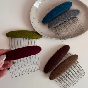 Close-up of elegant fabric oval hair combs in six assorted colors with silver metal teeth