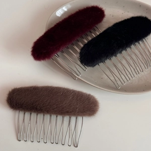 Dettaglio di pettini per capelli in peluche nei colori bordeaux, nero e marrone scuro