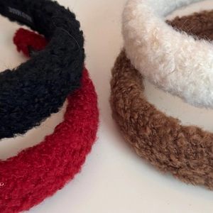 Macro detail of plush sherpa headbands showing thick texture and handmade inner labels
