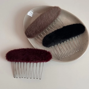 Dettaglio di pettini per capelli ovali in peluche e metallo in marrone, nero e bordeaux