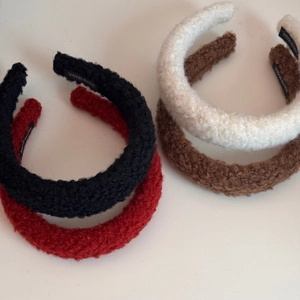 Detail of plush faux lamb wool headbands showing the handcrafted label and soft texture