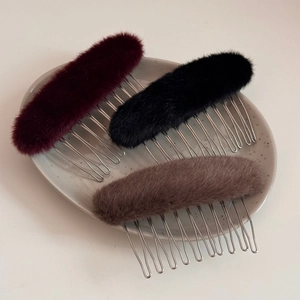 Vista ravvicinata di pettini laterali ovali in peluche bordeaux, neri e color moca