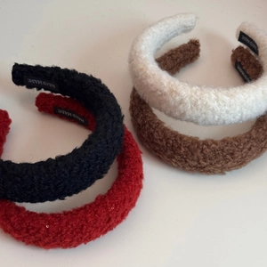 Detailed macro view showing the soft lamb wool texture and handmade labels of headbands