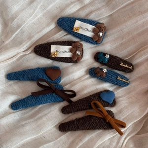 Detailansicht handgefertigter Tweed-Haarklammern mit Plüschbären- und Herzmotiven