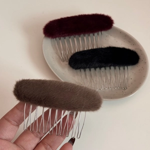 Dettaglio dei pettini per capelli ovali in peluche bordeaux, nero e marrone con denti metallici