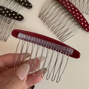 Detailed back view showing the metal teeth and acetic acid polka dot plate of hair comb