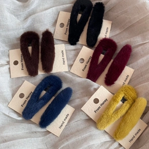 Detailansicht der flauschigen BB-Haarspangen in verschiedenen Winterfarben auf Stoff