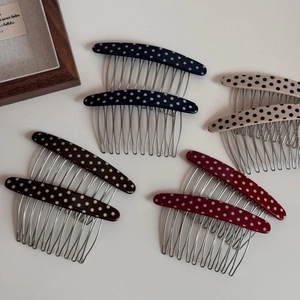 Close-up of four vintage polka dot hair combs with metal teeth in assorted colors
