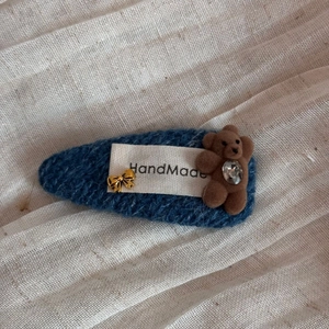 Detailansicht einer handgefertigten Strick-Haarklammer mit Bär und blauem Twill-Stoff-Design