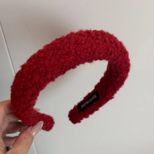 Detail of soft red fleece headband with hand made label and thick plush texture