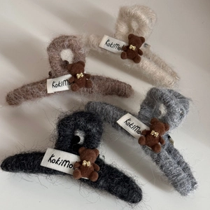 Detail view of plush shark hair claw clips with flocked bears in four neutral colors