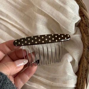 Detail of polka dot acetate hair comb with silver metal teeth for hair styling