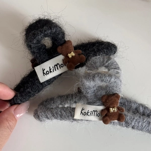 Close-up of fuzzy hair claw clip featuring a cute flocked bear with golden bow accent
