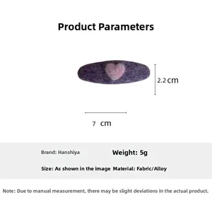 Detailed view of a purple plush hair clip with pink heart showing 7cm length and fabric texture