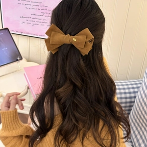 Brown velvet double bow banana clip hair accessory shown on a model's hairstyle