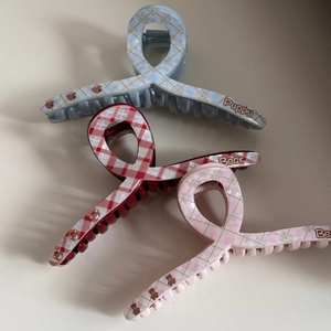 Detailed view of three checkered acetate hair claws with cartoon bear and puppy prints