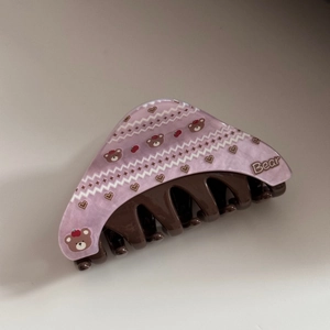 Detail of a purple acetate hair claw clip featuring cute bear and heart patterns