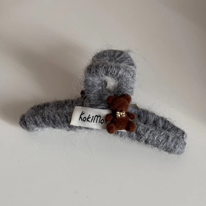 Detail showing plush gray faux fur hair claw clip with cute flocked brown bear ornament