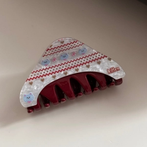 Detail of acetate triangular hair claw with kitten print and heart patterns in burgundy