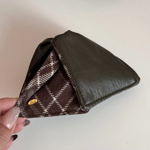 Close-up of triangle leather claw clip with green litchi grain and interior diamond pattern