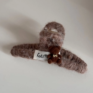 Detail view of large brown faux fur claw clip with flocked bear and KokiMe label