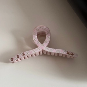 Detail view of pink acetate hair claw clip with bear print and checkered pattern