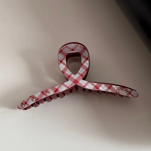 Detail view of burgundy checkered acetate hair claw clip with cute bear print pattern